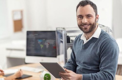 En kontorarbeider smiler fordi digitalisering av bedriften gjør jobben hans lettere.